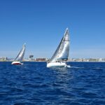 Régate de voiliers du Cercle Nautique de Palavas devant le littoral et la phare de Palavas-les-Flots.