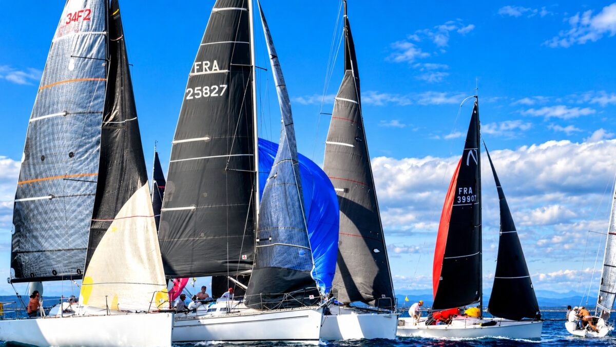 Voiliers sous spinnaker bleu et rouge durant le Grand Prix de Palavas 2026.